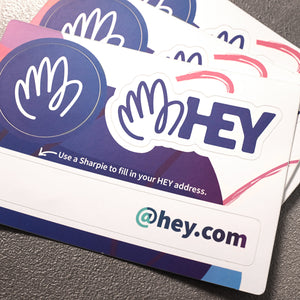 a sticker sheet with two HEY logo stickers, and a sticker to fill in your HEY email address
